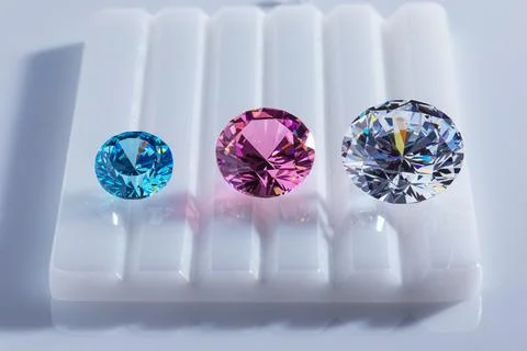 Coloured diamonds of different sizes at the workplace of a diamond expert Stock Photos
