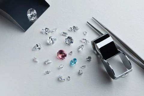 Coloured diamonds of different sizes at the workplace of a diamond expert Stock Photos