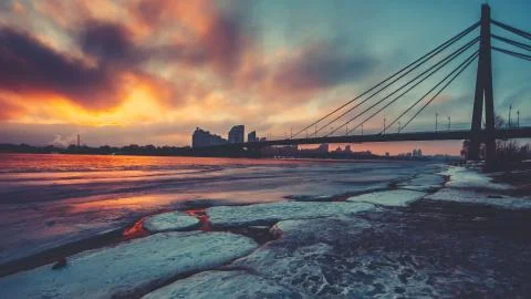 Coloured evening clouds float over half frozen Dnipro river Stockfoto's