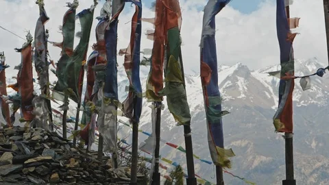 Coloured prayer flags on poles flap against severe snow mountains, Nepal Stock Footage 124677434
