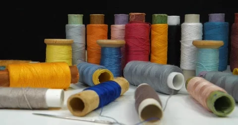 Coloured spools of thread lies on white table Stock Footage 317194766
