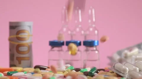 Coloured tablets and pills falling down on pink background Video stock 168172931