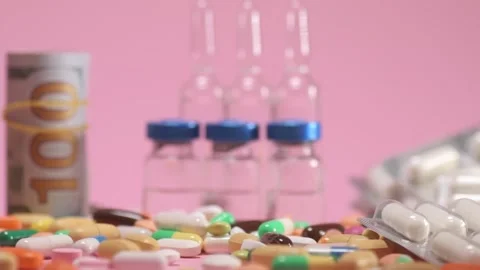 Coloured tablets and pills falling down on pink background Video stock 168172992