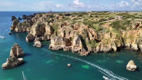 Colourful Algarve cliffs and meadows above turquoise water at Ponta da Piedade Stock Footage 310563554