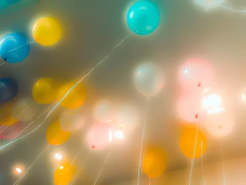 Colourful balloons float on the ceiling Stock Photos