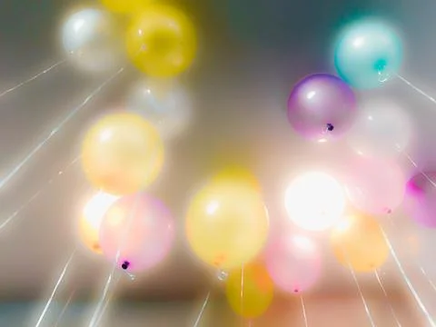 Colourful balloons float on the ceiling Stock Photos