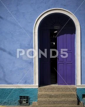 Colourful blue wall and purple painted front door in the Old City, Cartagena Stock Photos