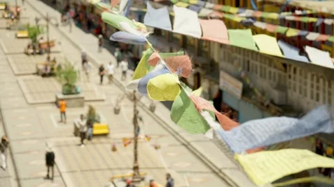 Colourful Buddhist prayer flags flutter over city street Stock Footage 282526822
