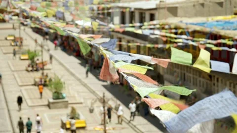 Colourful Buddhist prayer flags flutter over city street Stock Footage 282527137
