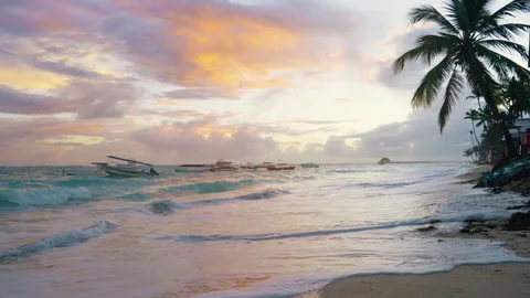 A colourful dawn sky behind waves lapping a Caribbean beach Stock Footage 316244774