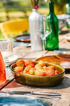 Colourful decorated table in summer setting with strawberries. Garden party Stock Photos