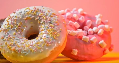 Colourful donuts rotating on table on pink background Stockbeeldmateriaal 122178203