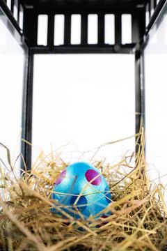 Colourful Easter egg in a nest within a decorative lantern Stock Photos