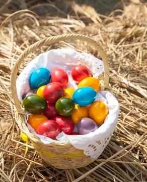 Colourful Easter eggs inside straw wicker, on straw Stock Photos