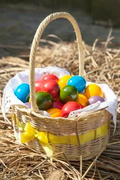 Colourful Easter eggs inside straw wicker Stock Photos