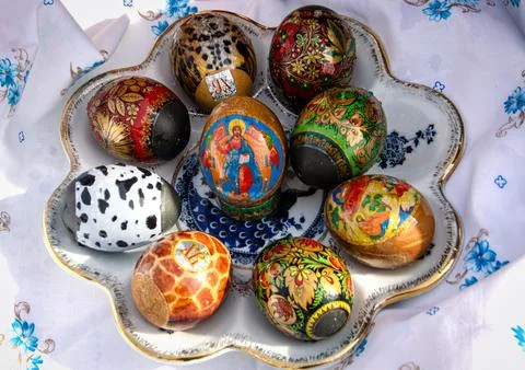 Colourful Easter eggs laid in ceramic plate on white tablecloth. Stock Photos