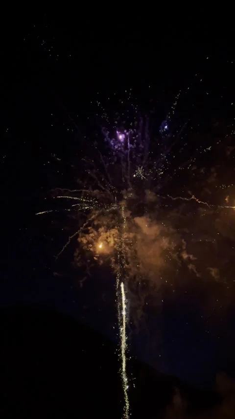 Colourful fireworks explode in the night sky, bright sparks surround the scene Video stock 313695448