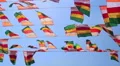 Colourful flags swaying against a blue sky HD Footage