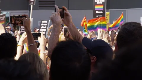 A colourful float rides by people dancing and hyping the crowd at a pride parade Stock Footage 124346287