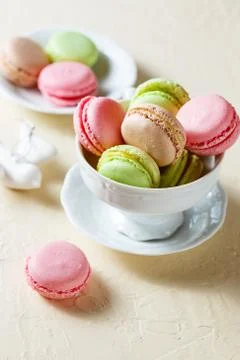 Colourful macaroons on the plates Stock Photos