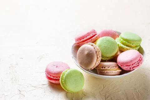 Colourful macaroons on the plates Stock Photos