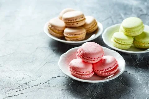 Colourful macaroons on the plates Stock Photos