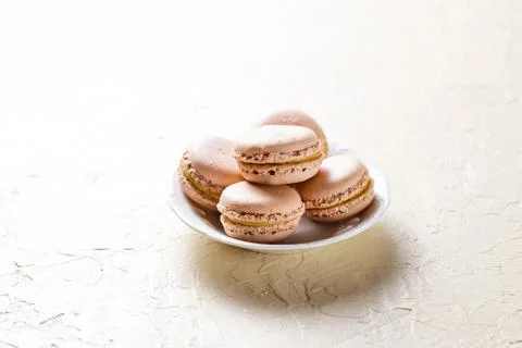 Colourful macaroons on the plates Stock Photos