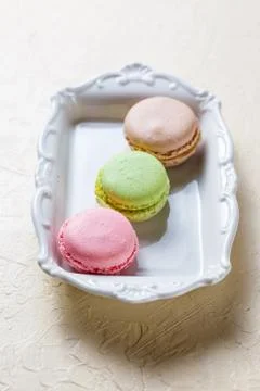 Colourful macaroons on the plates Stock Photos