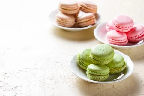 Colourful macaroons on the plates Stock Photos
