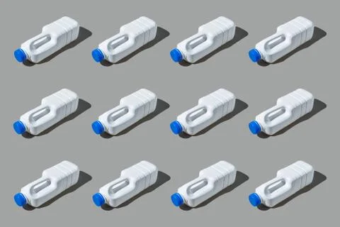 Colourful pattern of white plastic bottles on grey background. View from top. Stock Photos