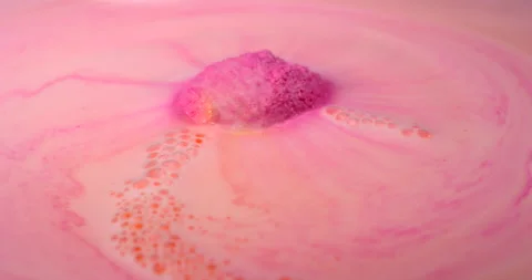 Colourful pink bath bomb dissolves in a warm water with foam and bubbles Stock Footage 146173952
