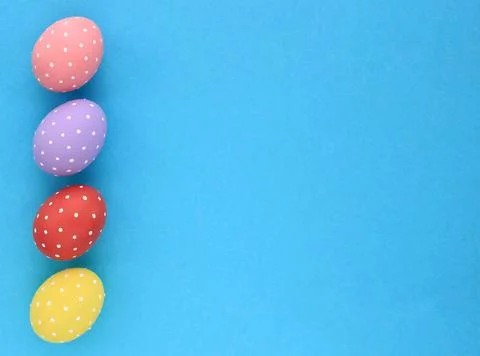 Colourful polka dot painted Easter eggs on blue background top view Stock Photos
