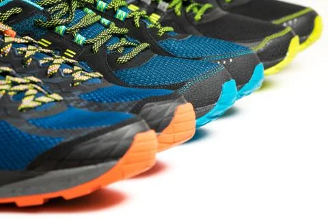 Colourful running shoes / exercise trainers on a white floor Stock Photos