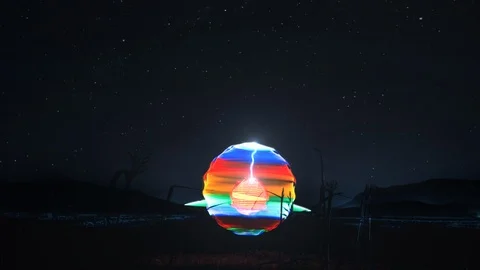 Colourful, shiny, glowing light globe moves on a field and striking light bolts. Stock Footage