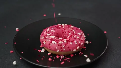 Colourful sprinkle falls on Pink Glazed Doughnut. Slow-mo. 120fps Stock Footage 237300759