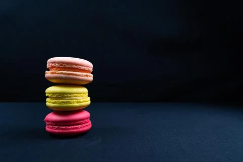 Colourful stack of macaroons isolated on plain black background. Copyspace Stock Photos
