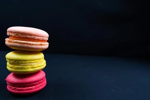 Colourful stack of macaroons isolated on plain black background. Copyspace Stock Photos