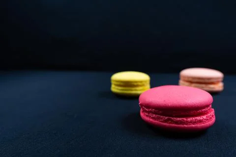 Colourful stack of macaroons isolated on plain black background. Stock Photos