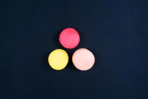 Colourful stack of macaroons isolated on plain black background. Stock Photos