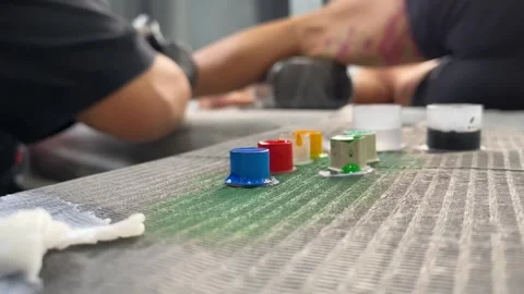 Colourful tattoo ink cup on flat table with blurred tattoo artist working Stock Footage 267654901