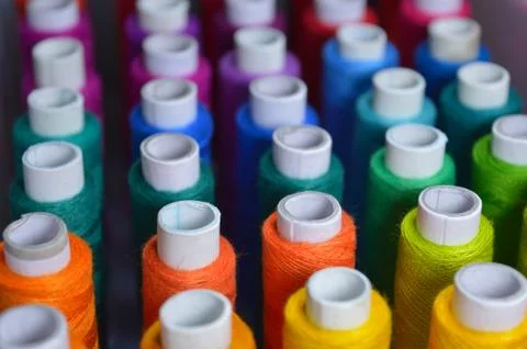 Colourful thread rolls arranged in a box. Some parts of the image are infocus Stock Photos