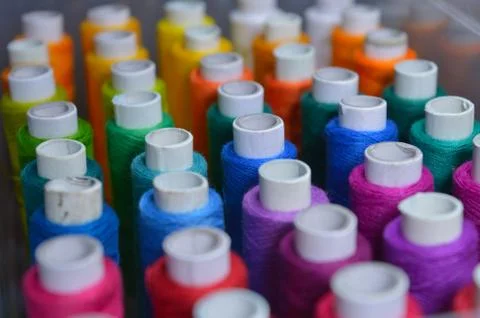 Colourful thread rolls arranged in a box. Some parts of the image are infocus Stock Photos