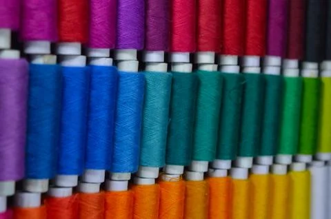 Colourful thread rolls arranged in a box. Some parts of the image are infocus Stock Photos