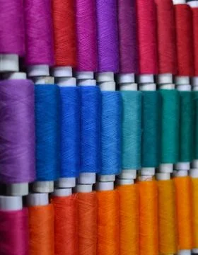 Colourful thread rolls arranged in a box. Some parts of the image are infocus Stock Photos