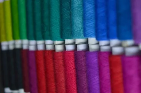 Colourful thread rolls arranged in a box. Some parts of the image are infocus Stock Photos