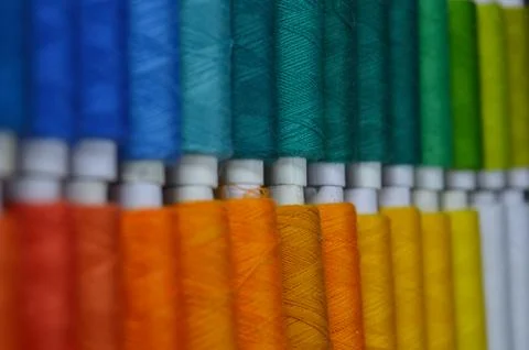 Colourful thread rolls arranged in a box. Some parts of the image are infocus Stock Photos