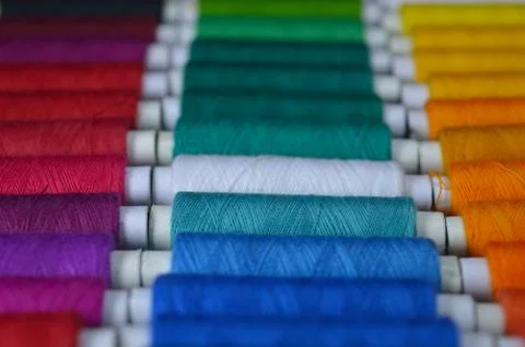 Colourful thread rolls arranged in a box. Some parts of the image are infocus Stock Photos