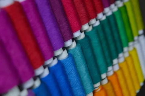 Colourful thread rolls arranged in a box. Some parts of the image are infocus Stock Photos