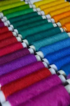 Colourful thread rolls arranged in a box. Some parts of the image are infocus Stock Photos