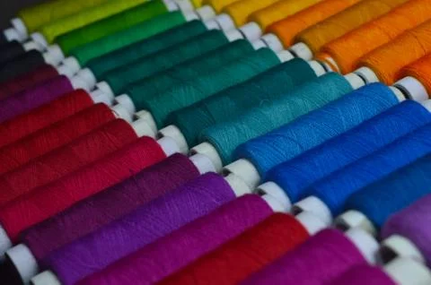 Colourful thread rolls arranged in a box. Some parts of the image are infocus Stock Photos
